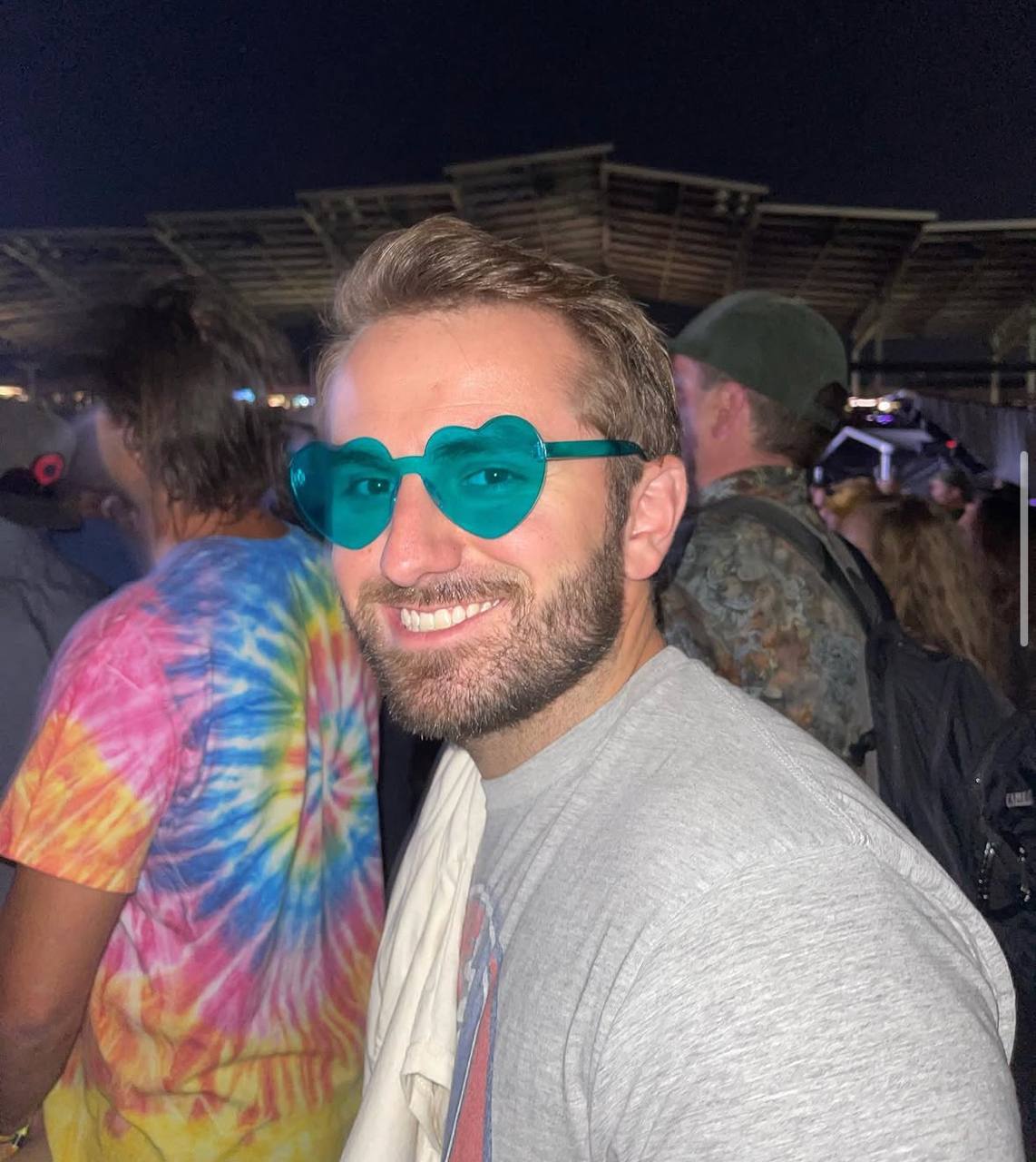 DJ Maz smiling in teal heart-shaped glasses
